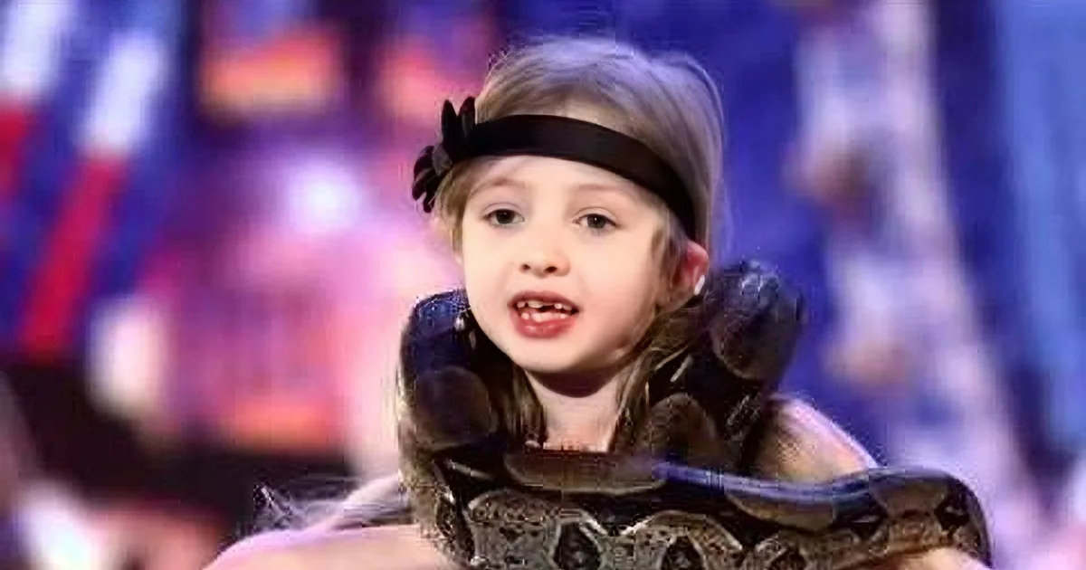 A young girl with a headband and snake-like patterns around her face and body.