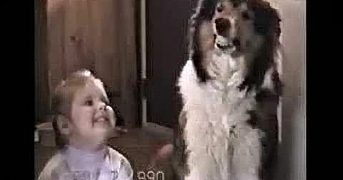 A baby and a dog are looking up, with the dog appearing to be barking or howling.