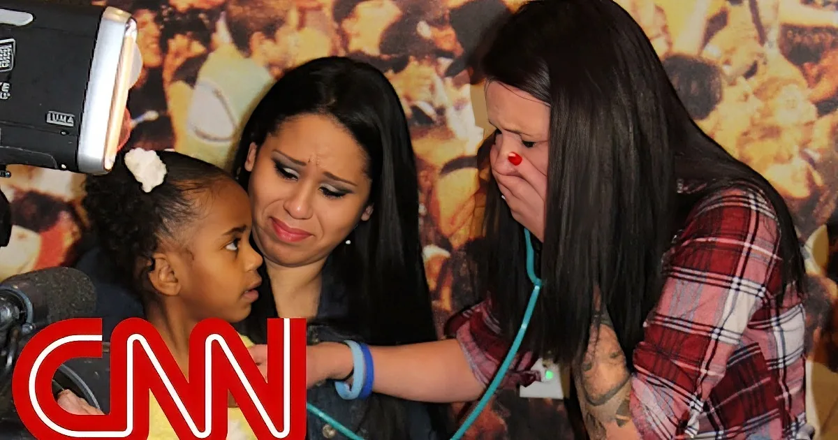 A woman in a plaid shirt is examining a child's ear with a stethoscope, while another woman looks on with concern.