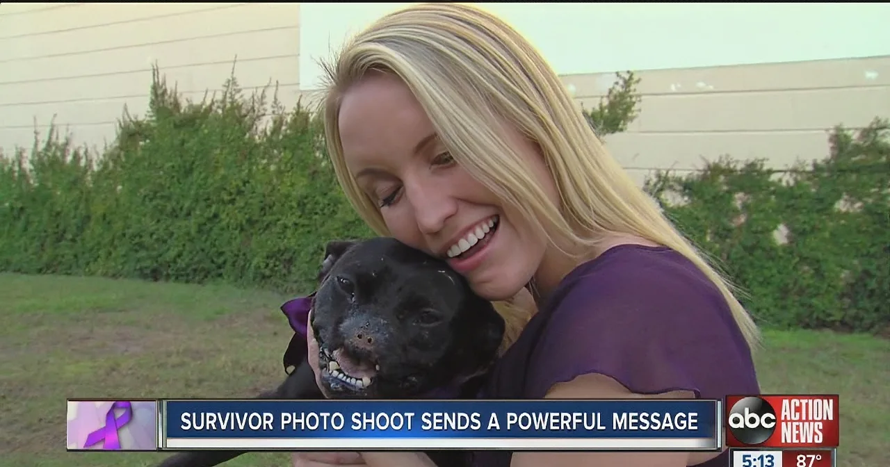 A woman hugs a black dog, smiling, with a news banner about a survivor photo shoot.