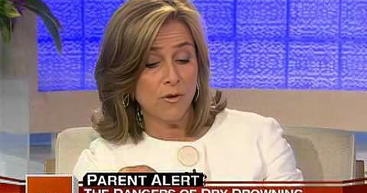 A woman with shoulder-length hair, wearing a white top, is speaking on a news program.