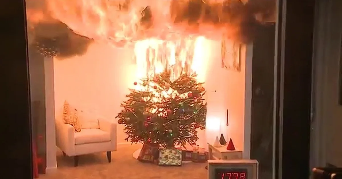 A Christmas tree is engulfed in flames, with smoke and fire billowing around it.