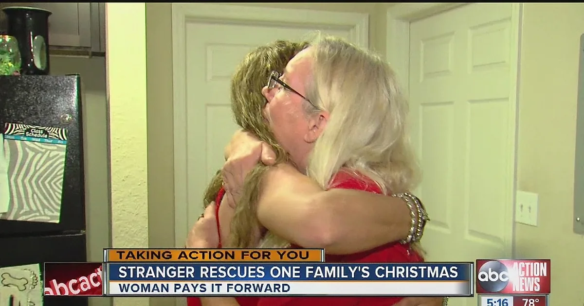 A woman hugs another, both in red, with text below about a stranger rescuing a family's Christmas.