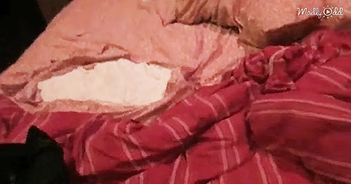 A close-up of a person's lips with a white substance applied, partially covered by a red and white striped cloth.