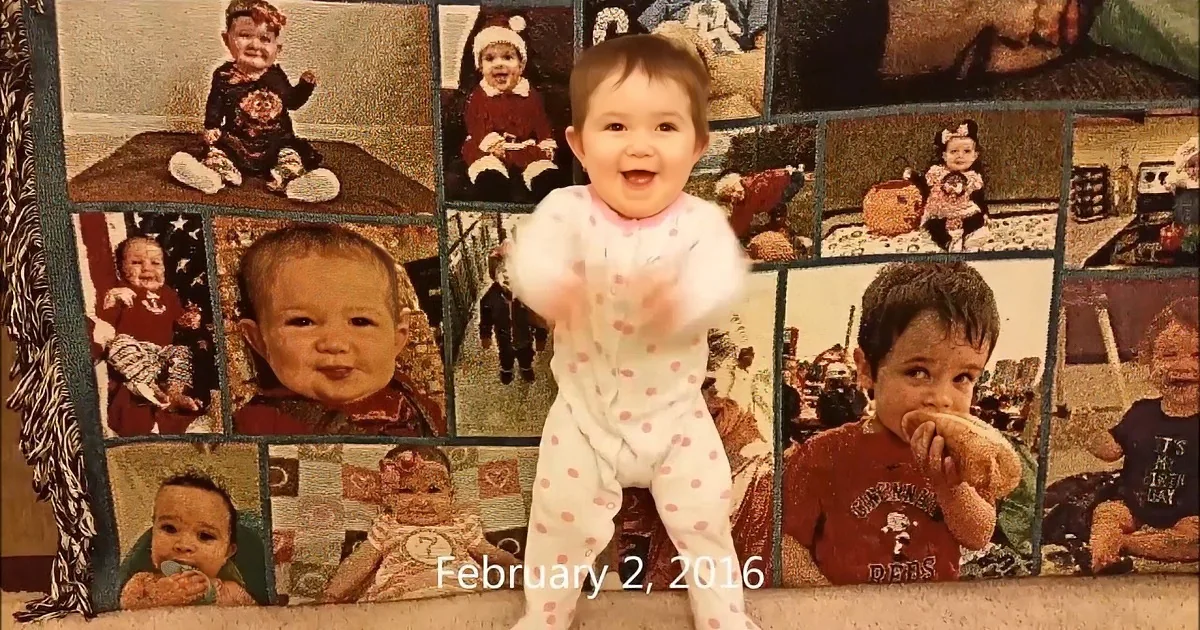A baby in pajamas claps in front of a collage of baby photos, dated February 2, 2016.