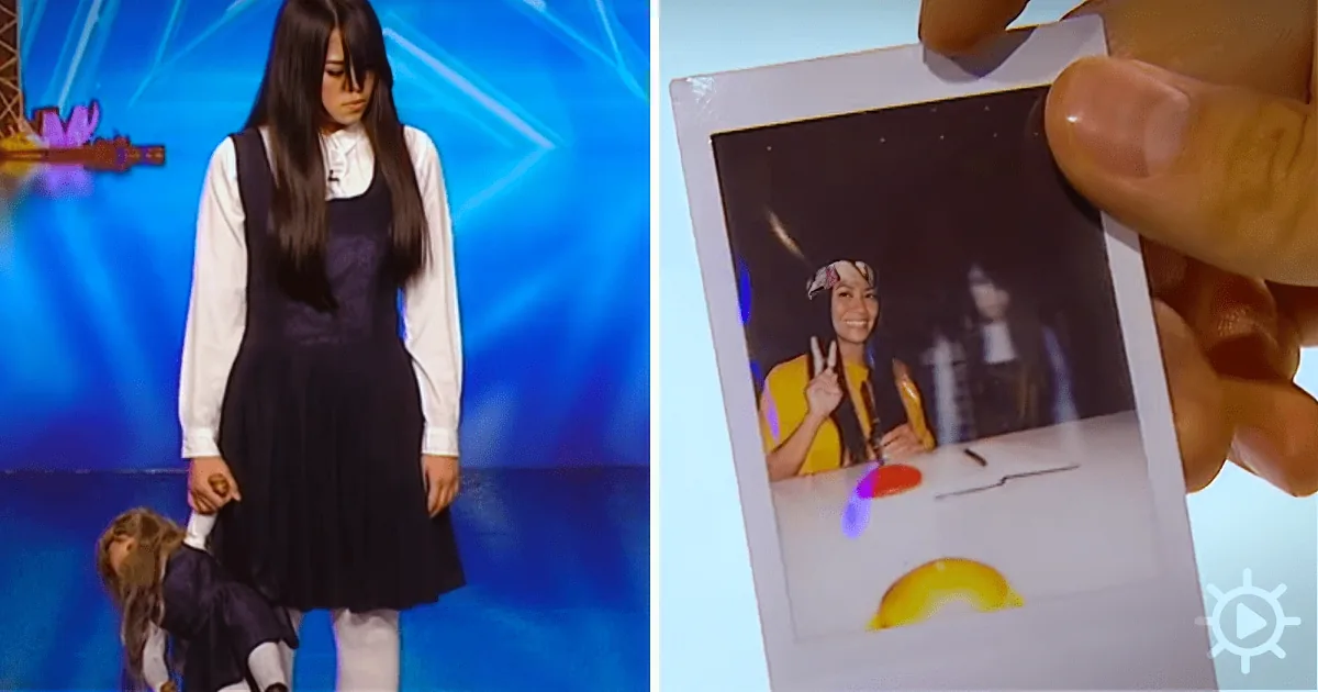 A woman in a school uniform stands on stage, while a hand holds a Polaroid photo showing a person making a peace sign.