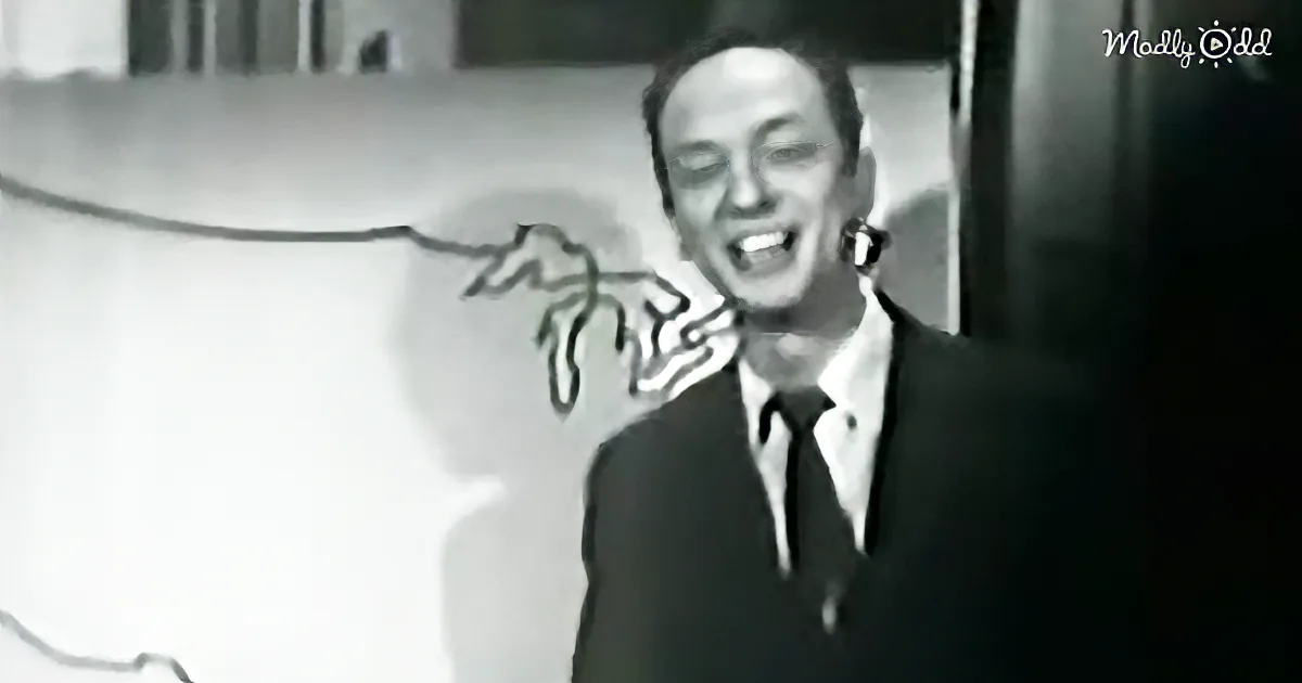 A man in a suit and tie is smiling, with a cartoonish hand pointing at him.