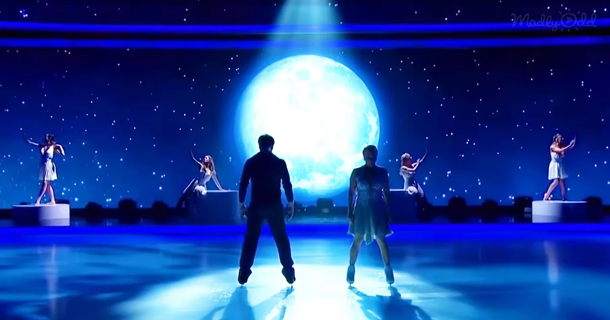 A couple ice skating under a bright blue spotlight with a large moon and stars in the background.