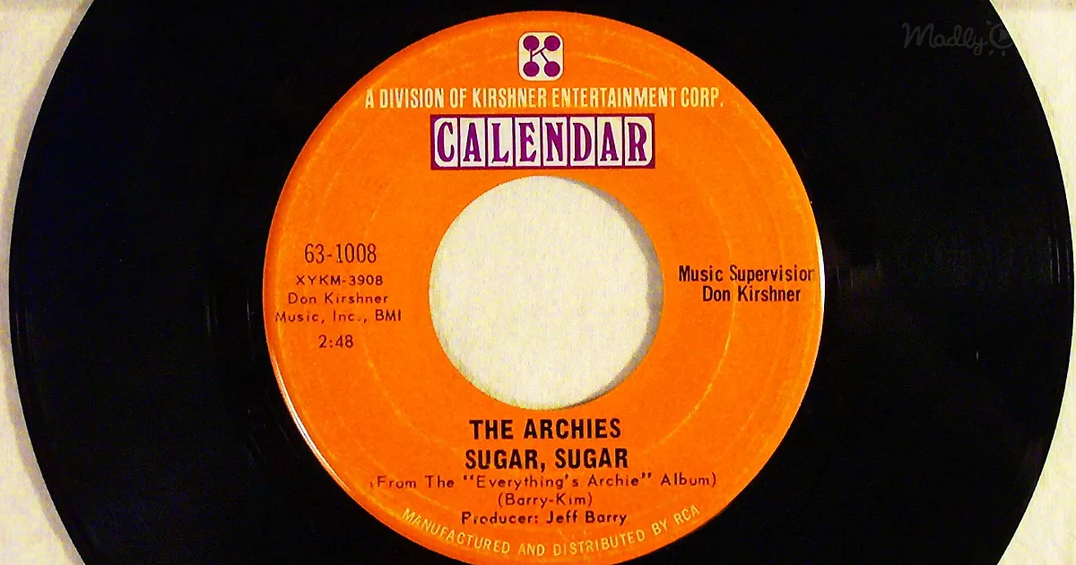 A vintage vinyl record label for "Sugar, Sugar" by The Archies, featuring bright orange and purple design elements.