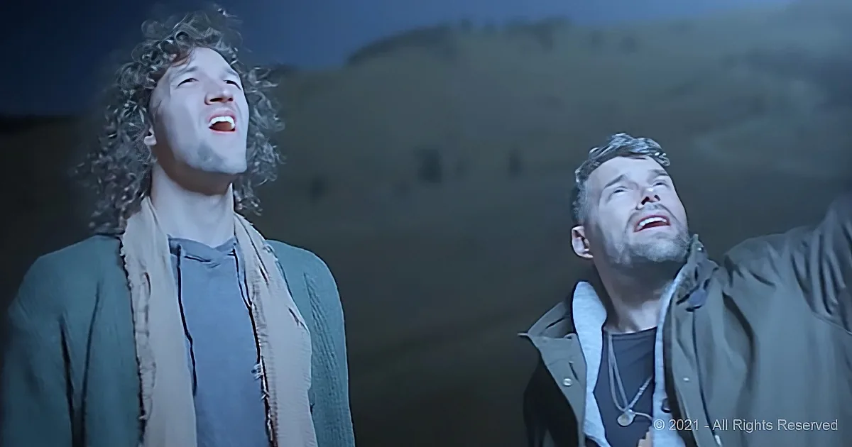 Two individuals with curly hair, one in a green jacket and scarf, the other in a brown jacket, both looking upwards with...