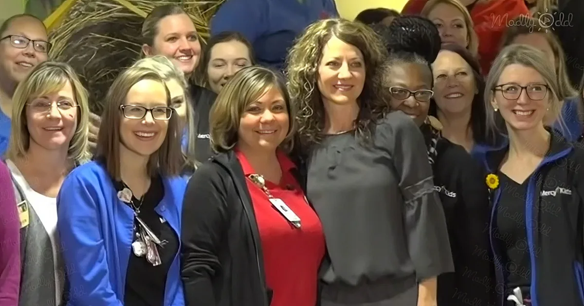 A group of smiling women in professional attire pose together for a photo.