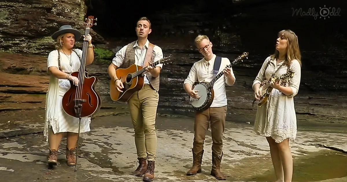 A group of four musicians play instruments in a natural setting, surrounded by rock formations.