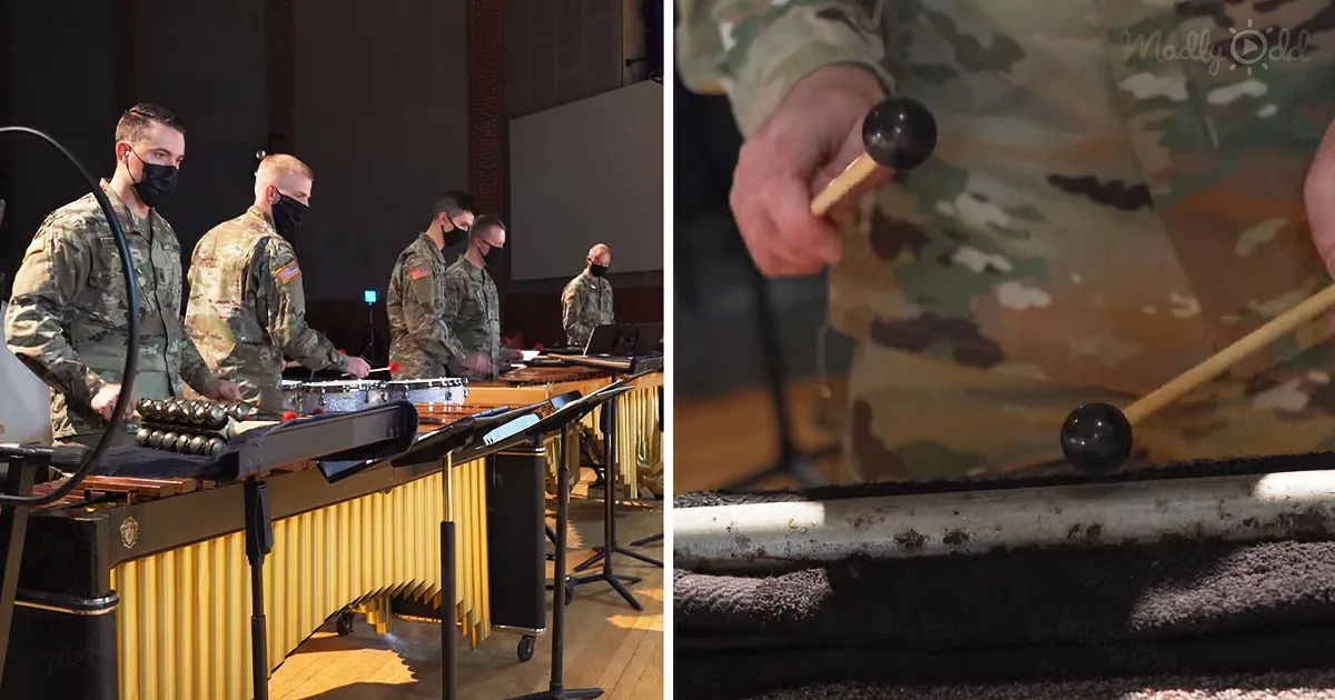 Military musicians in camouflage uniforms play marimbas in a dimly lit room.