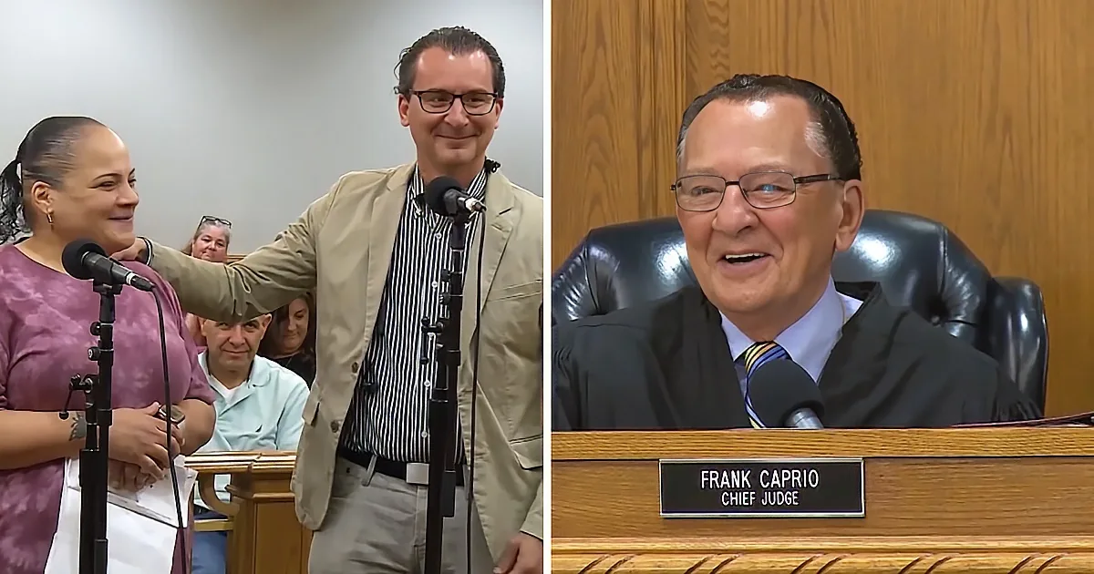A man in a suit stands next to a woman at a podium, while a judge named Frank Caprio sits behind a desk.