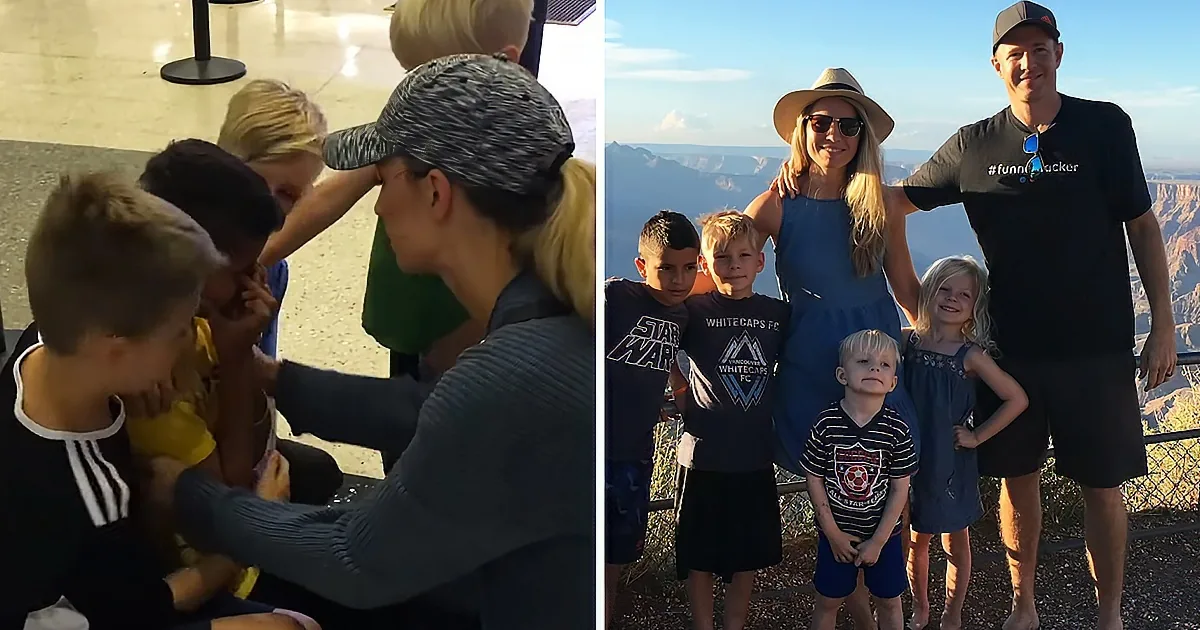 A family of six enjoys a sunny day at a scenic overlook, with one child getting a playful touch from a woman.