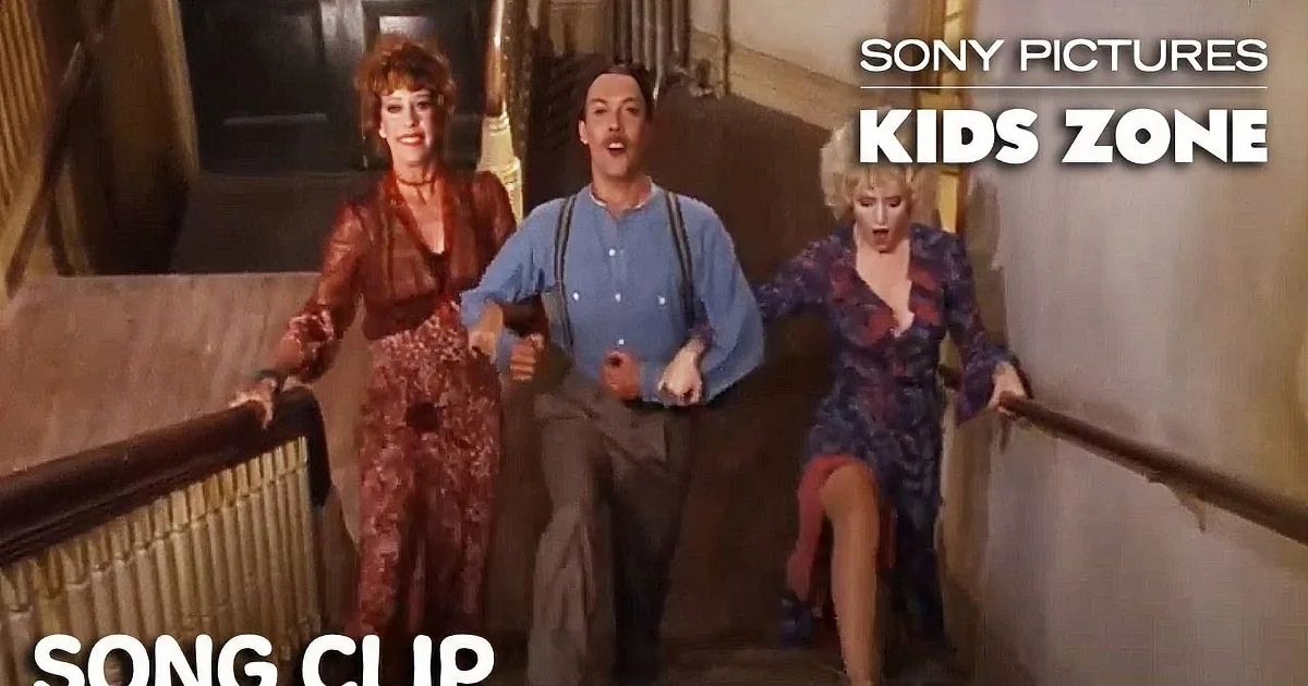 A man in a blue shirt and suspenders is walking down a staircase flanked by two women in dresses.