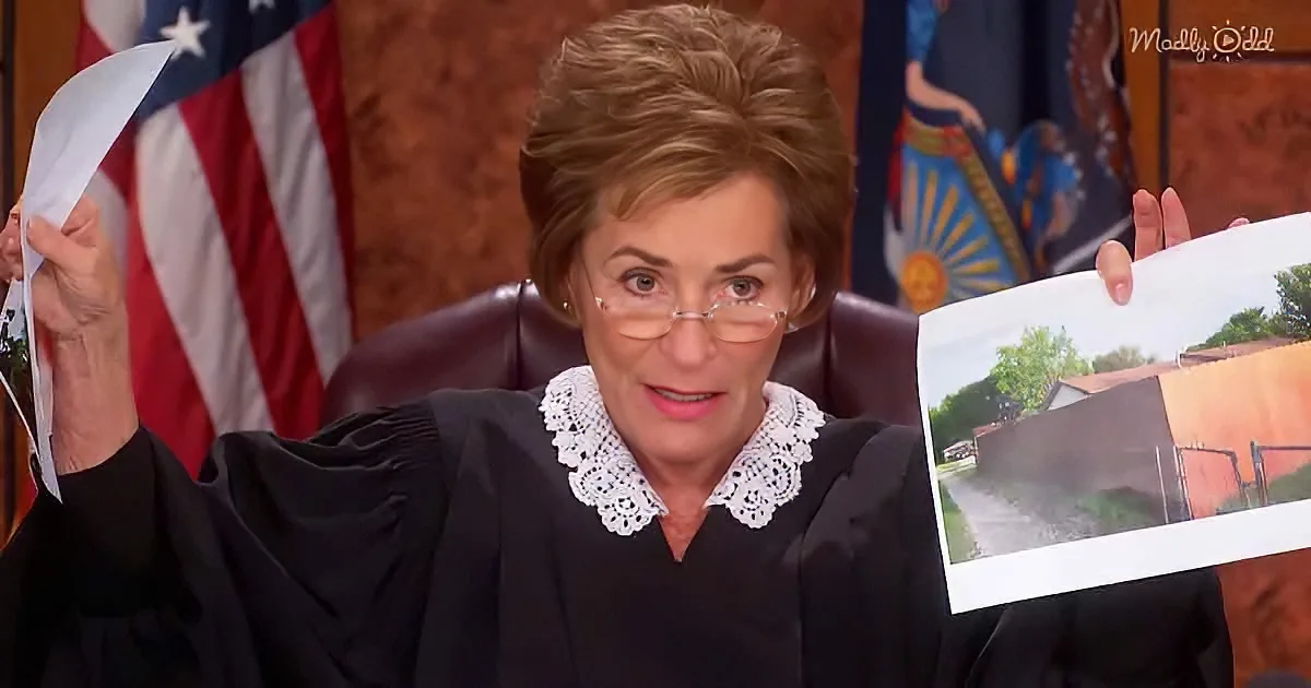 Judge in black robe holds papers and photo, American flag and flags behind her.