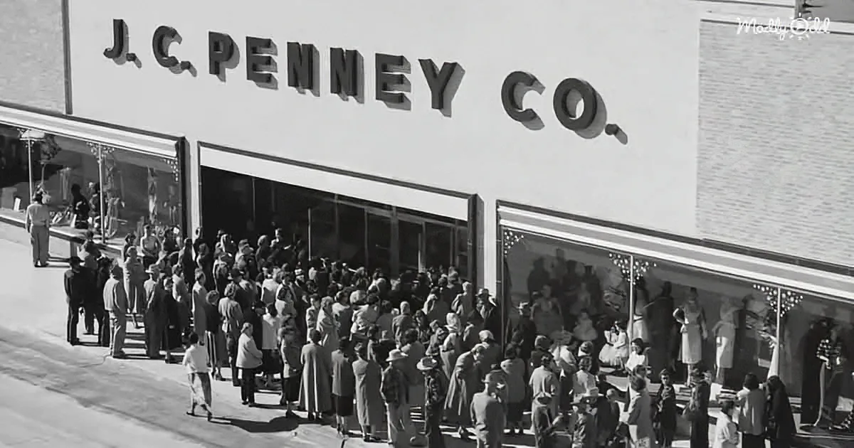 A large crowd gathers outside a J.C. Penney Co. store, with people dressed in mid-20th-century fashion.