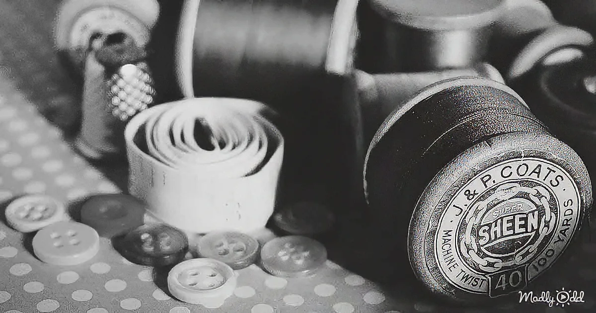 A spool of J&P Coats Super Sheen thread sits among buttons and sewing notions on a polka-dotted fabric.