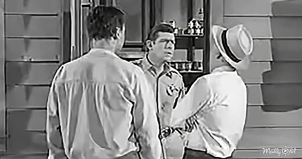 A man in a white shirt and hat is holding a plant, facing two other men in a room.