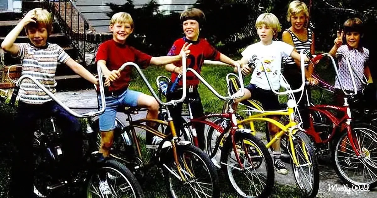 Six children with bicycles smile and pose outdoors, showcasing their colorful bikes.