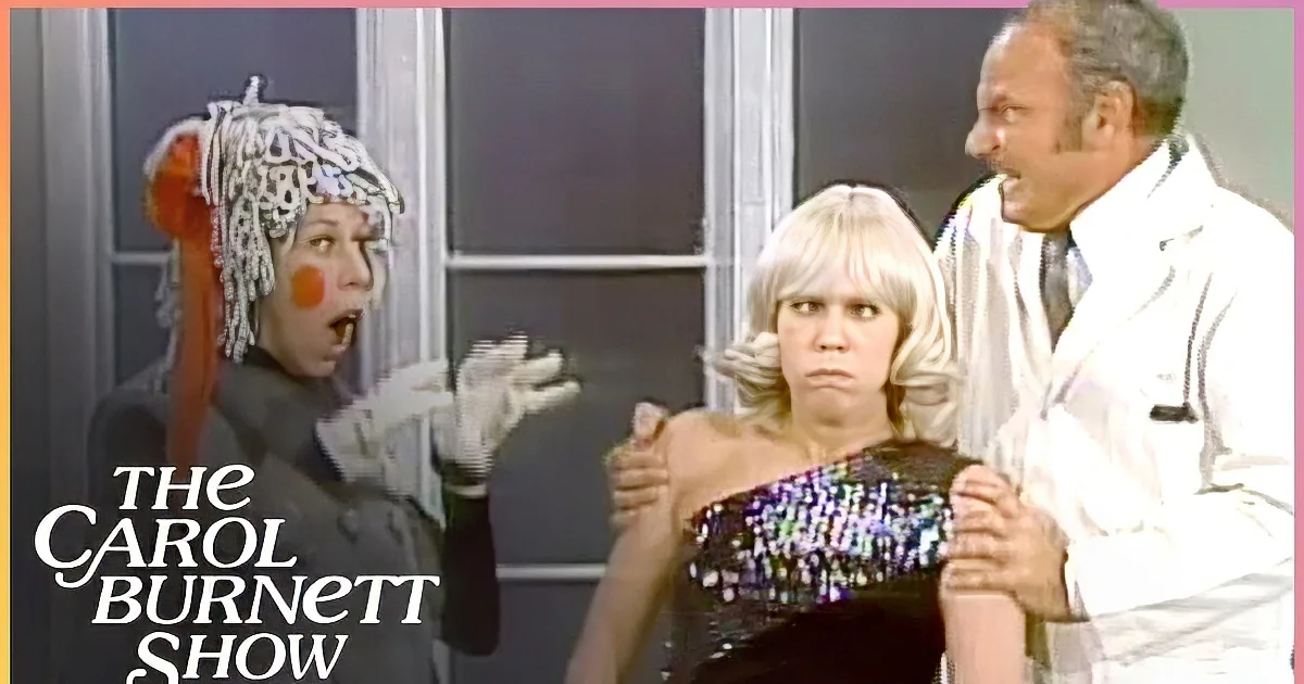 A woman in a black outfit with a white, curly wig and orange accents is next to another woman in a blue dress with a...