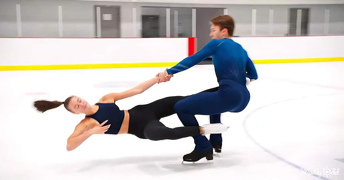 A figure skating couple performs a dynamic pose on the ice, with the man supporting the woman in a dramatic lean.