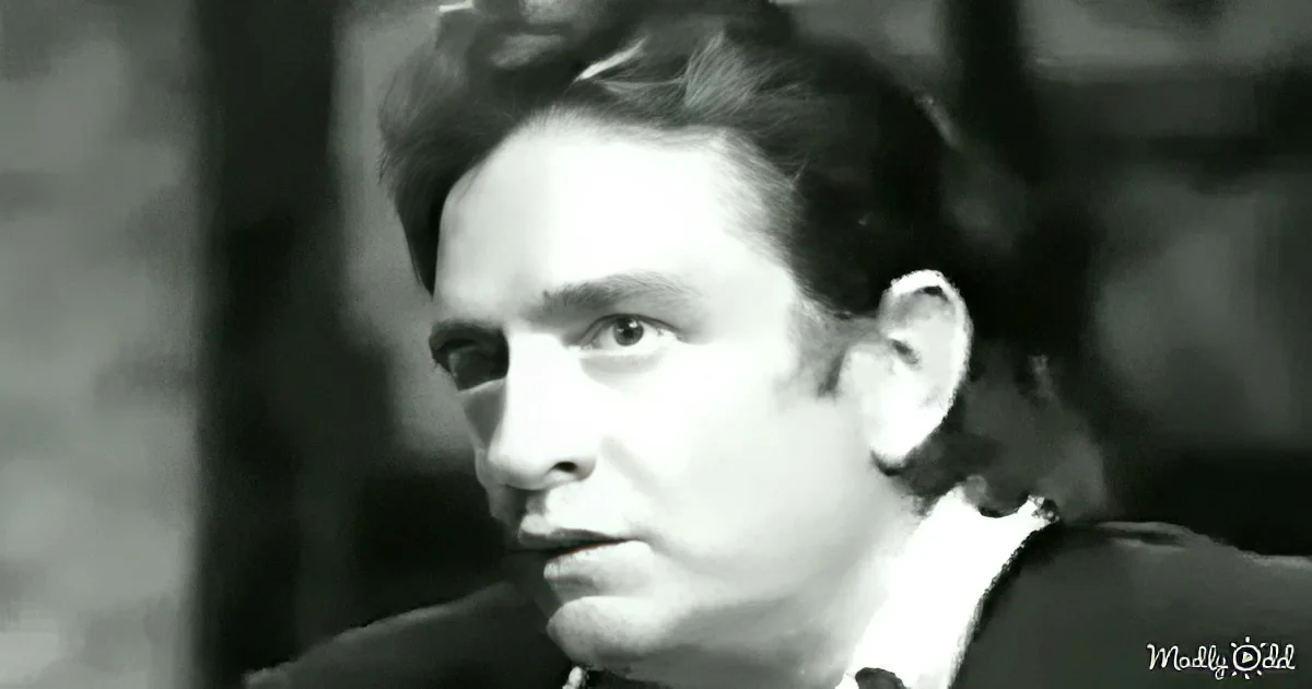 A man in a suit and tie, looking to the side with a serious expression.