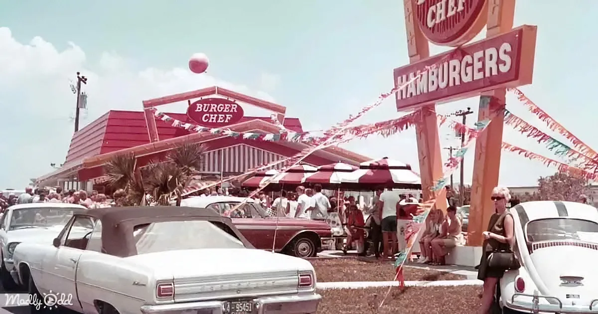 A Burger Chef restaurant with vintage cars, people, and festive decorations in the foreground.