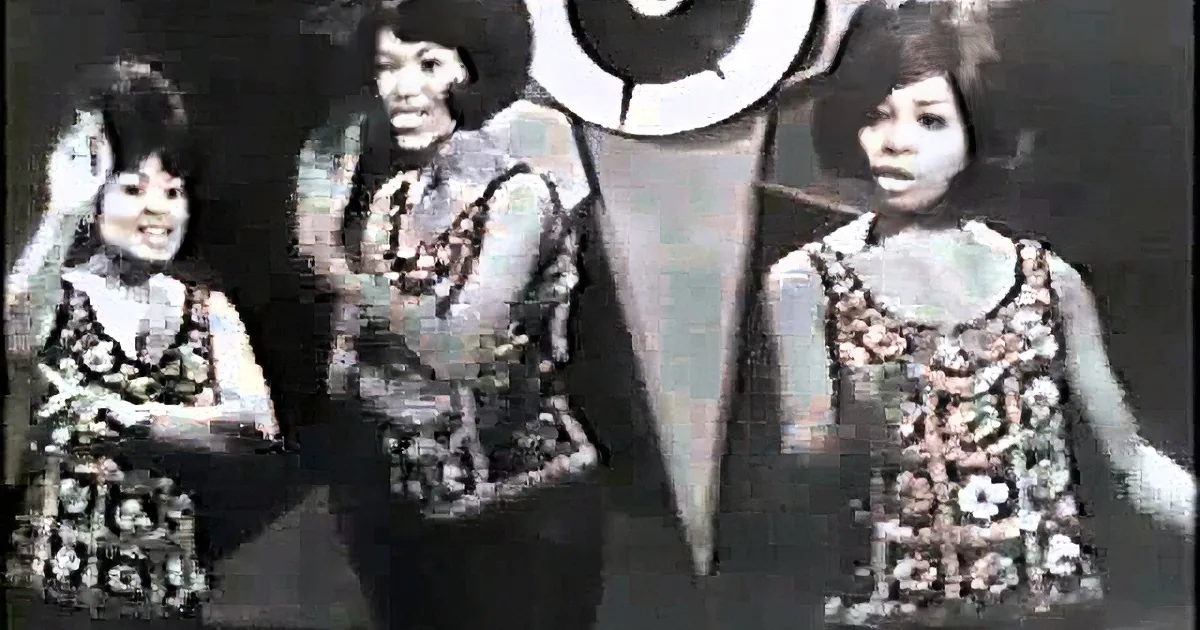 A woman in a pink dress dances on stage, surrounded by four other women in matching outfits.