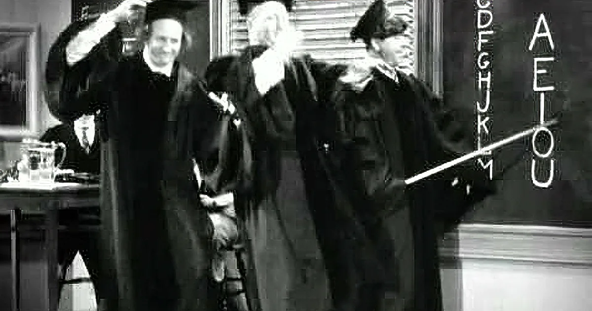 Three men in academic robes and caps stand in front of a chalkboard, gesturing animatedly.