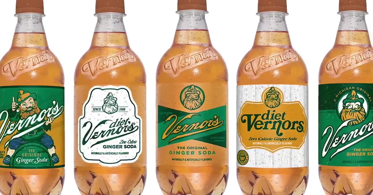 A man sits in a horse-drawn Vernors Ginger Ale delivery wagon in front of a dry cleaning and dyeing shop.
