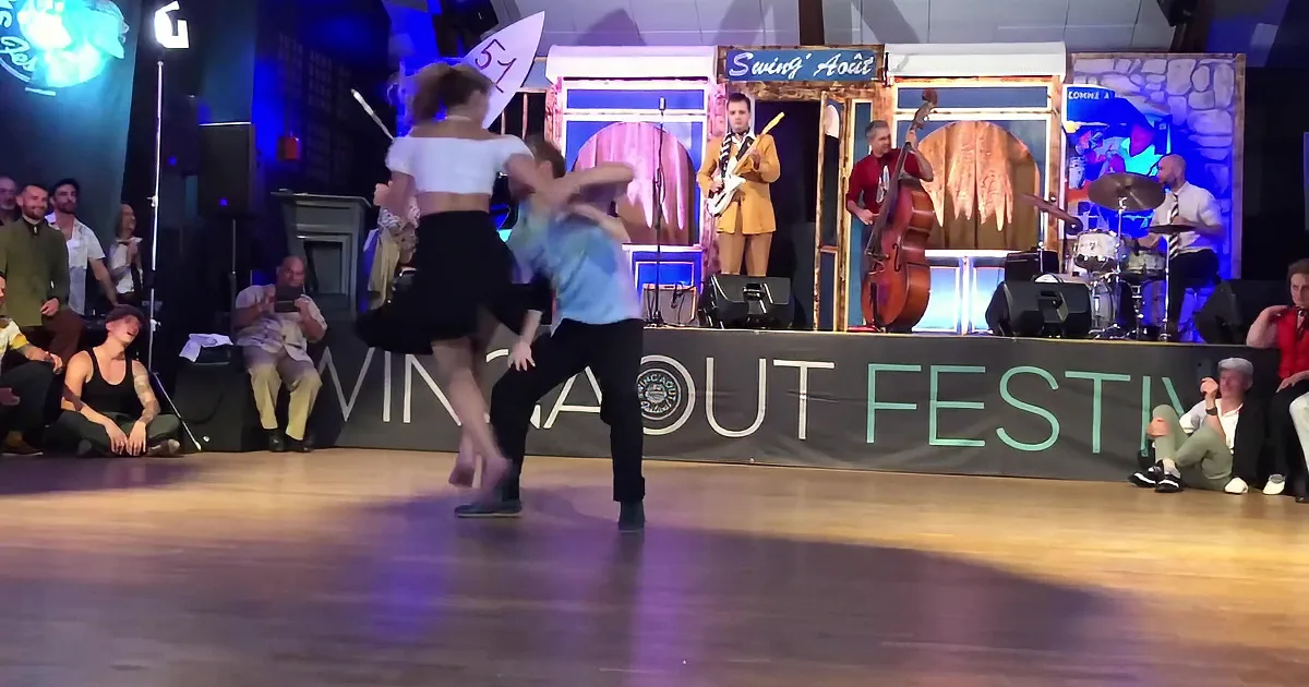 A couple dances on a stage with a band in the background at the "Swing Août Festival."