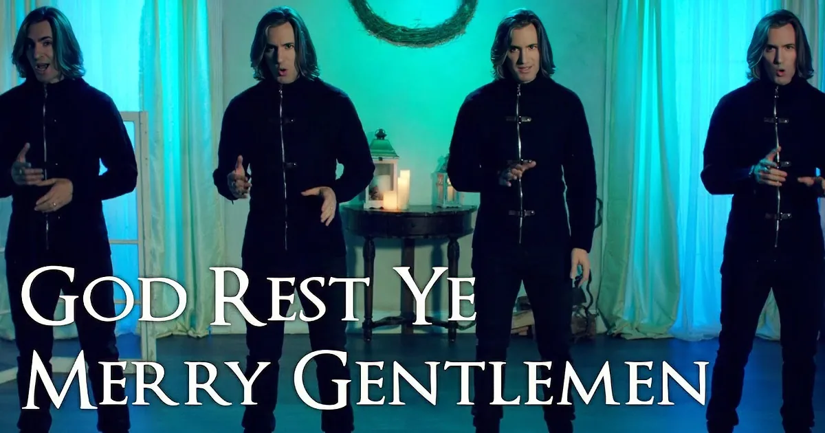 Four identical men in black outfits stand in a row, smiling and gesturing, against a blue-lit background with a wreath...