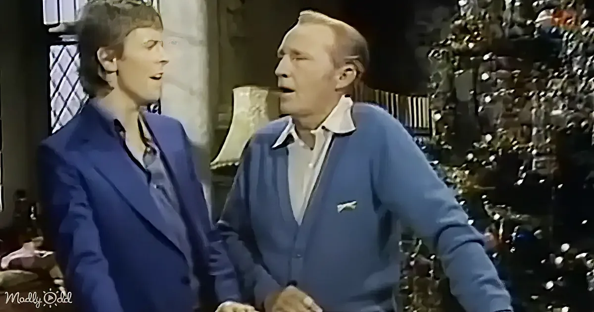Two men in blue attire are engaged in conversation, one gesturing with his hands.