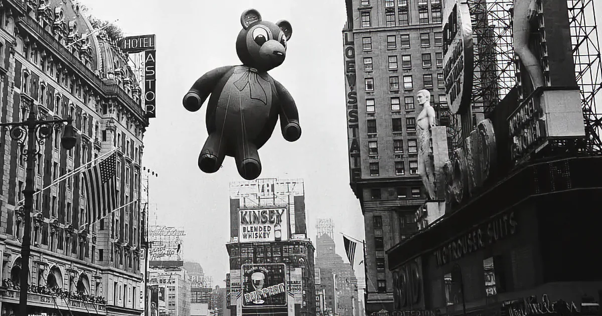 A large, smiling cartoon character balloon floats above a bustling parade, surrounded by spectators and city buildings.
