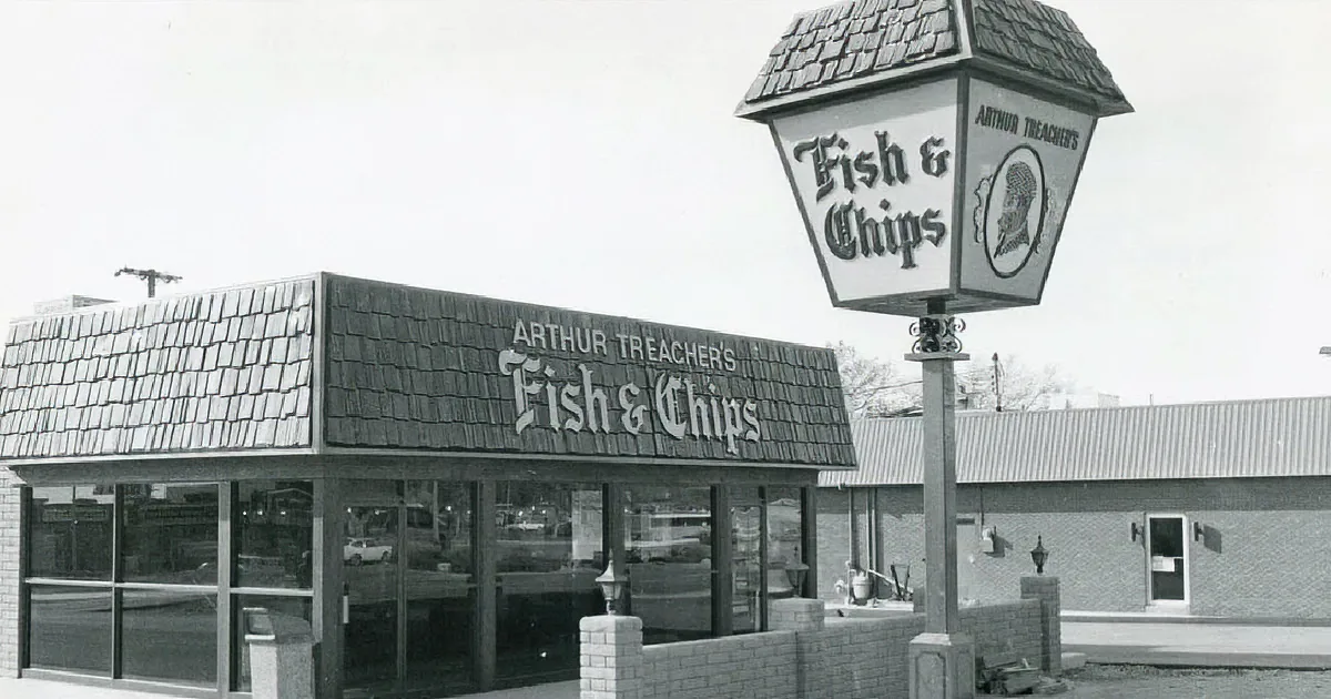 A vintage Arthur Treacher's Fish & Chips restaurant with a sign and a lamp post.