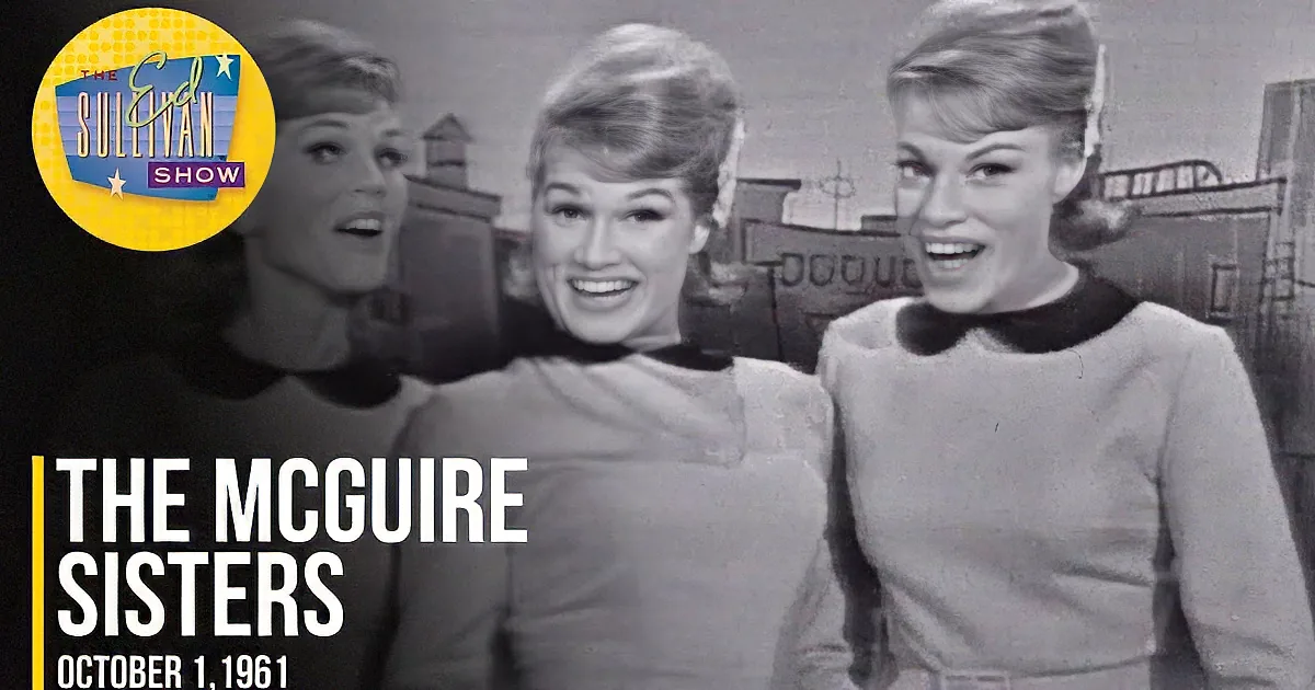 Three women in matching outfits smile and pose together, with a cityscape in the background.
