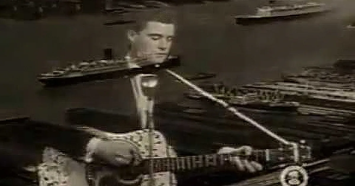 A man with slicked-back hair and a suit, possibly from a classic film or music video.